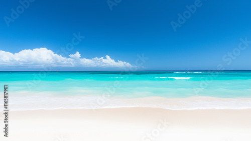 Tropical beach with turquoise water, waves gently rolling onto white sand as tide comes in