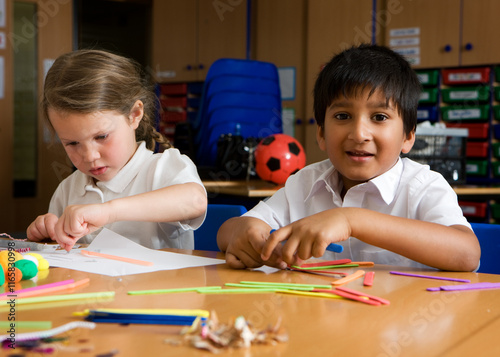 Elementary School: Creative Play. A happy glance from a primary school boy of South Asian heritage at play with a fellow pupil in their classroom.