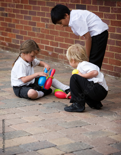 Elementary School: Playing Together. A group of primary age children learning to play together in the school yard under the supervision of their teacher. photo