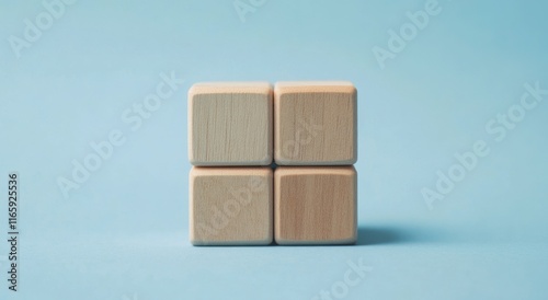 A simple arrangement of four wooden blocks on a light blue background, showcasing minimalistic design and clean lines.