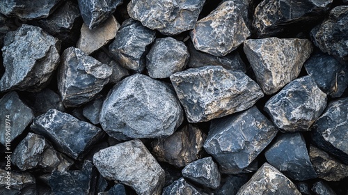 Pile of rocks with a grayish blue color. The rocks are scattered and piled up in different sizes. The image has a rugged and rough appearance, giving off a sense of strength and durability photo