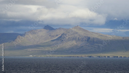 côte nord de l'Islande, falaise et plateau enneigé avec villages colorés photo