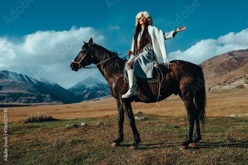 Young traditional kyrgyz woman ride on horse in high mountains photo