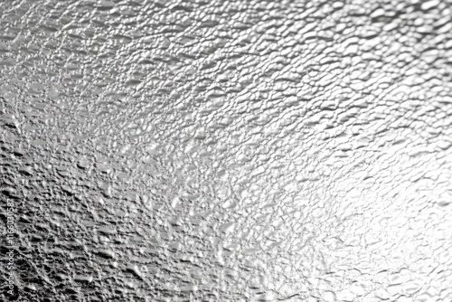 A black and white photo of a person riding a wave on a surfboard