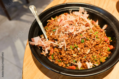 close up of Chinese Hong Kong Cantonese style soy sauce duck breast fried rice in a black clay pot with a spoon photo