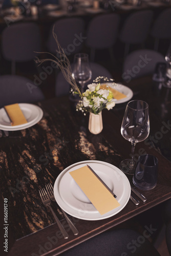 luxury tableware beautiful table setting in restaurant. banquette luxury arrangement plates and glasses. Glasses, forks, knives, napkins and decorative flower on a dark old brown wooden table. photo