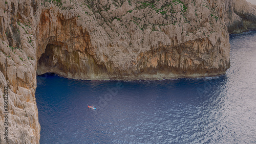Tropical landscape. Kayak on crystal clear water among rocks and stones. View from above. Sardinia