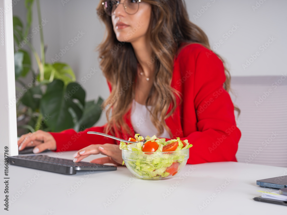 Busy businesswoman forgot to eat her salad, cropped side view image of caucasian female office worker typing on keyboard looking computer screen. Busy entrepreneur forgot to eat her salad. Busy businesswoman forgot to eat her salad, cropped side view image of caucasian female office worker typing on keyboard looking computer screen. Busy entrepreneur forgot to eat her salad.