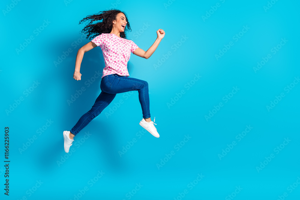 Obraz premium Full length photo of cheerful pretty lady dressed pink t-shirt running jumping high empty space isolated blue color background