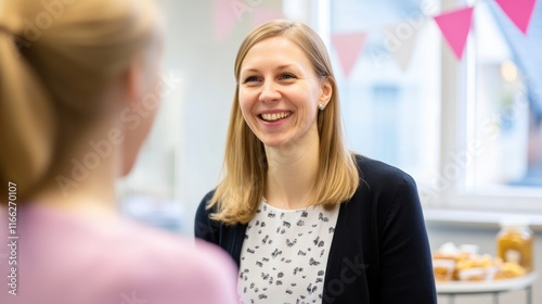 A smiling woman engages in conversation at a social gathering with light decorations. Free Download A smiling woman engages in conversation at a social gathering with light decorations. - GFXLoad