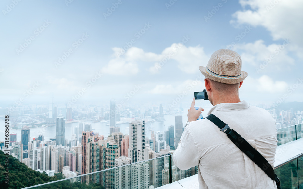 Travel businessman take photo lanscape view of Hong Kong cityscape skyline and Victoria harbor at the roof top of The Peak Tower Sky Terrace 428, Hong Kong, China. Travel businessman take photo lanscape view of Hong Kong cityscape skyline and Victoria harbor at the roof top of The Peak Tower Sky Terrace 428, Hong Kong, China.