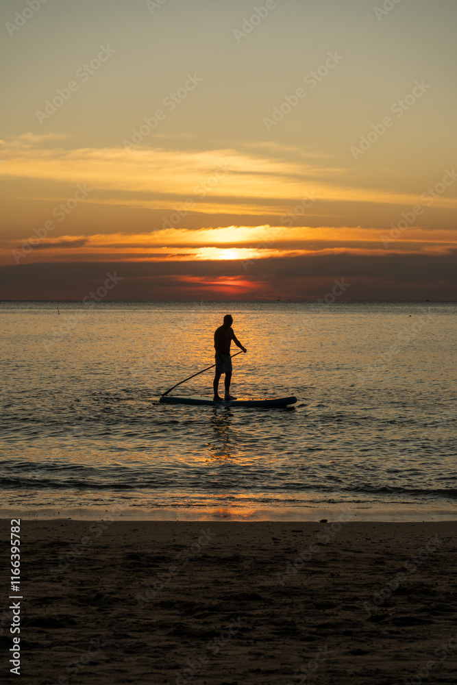 Fototapeta premium silhouette of a paddle boarder on the sunset
