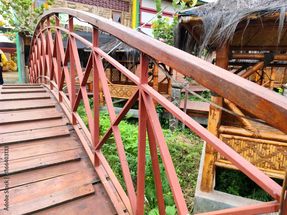 Curved Wooden Pedestrian Bridge with Rustic Thatched Roof Structure Curved Wooden Pedestrian Bridge with Rustic Thatched Roof Structure