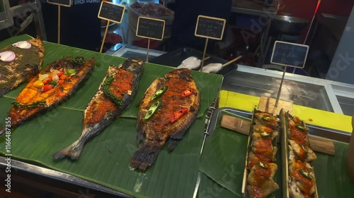 Local Asian Street Food. Assorted cooked street food ready to eat. Traditional Asian street food at a Night Market. Cinematic Foodie Concept. Meat, fish, vegetables. Ho Chi Minh City, Vietnam.