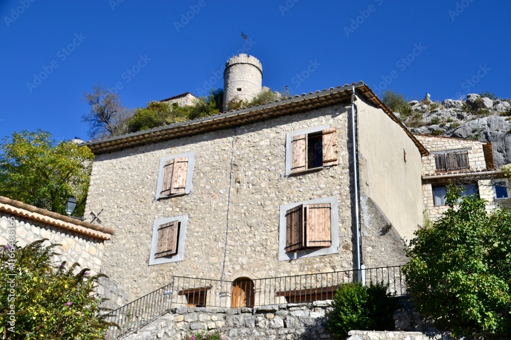 Fototapeta premium House in Provence village with chateau behind on hill