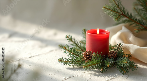 lighted red candle with evergreen pinecones