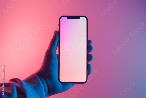 A hand holds a smartphone with a blank screen, set against a richly hued pink and blue gradient background. The image conveys modern technology and lifestyle with a contemporary and stylish aesthetic. photo