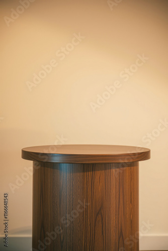 round wooden pedestal table against beige wall