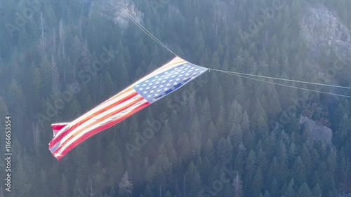 Largest US American flag floating and waving majestically in the breeze over a forested canyon in Ogden Utah -hike to the Major photo