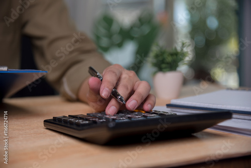 man accountant is pressing a calculator calculating income tax financial, planning and managing investment and saving according to the goal.