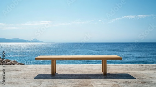 Fototapeta Naklejka Na Ścianę i Meble -  Serene wooden table on beach terrace overlooking tranquil sea ideal for product display or mockup against clear blue sky