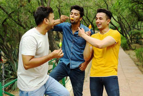 Indian male models are enjoying ice cream in the park.