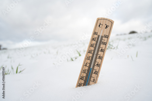 Thermometer in snow covered landscape, cold frosty weather forecast in winter, measure the temperature