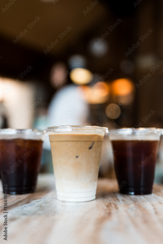 Close up view a glass of ice latte placed on the center between ice black coffee, desk blurred background, drink beverage Close up view a glass of ice latte placed on the center between ice black coffee, desk blurred background, drink beverage