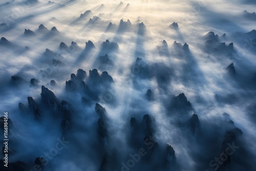 The majestic mountains of China. The sun shines through the fog on top of many layers of mountain peaks, forming light spots like diamonds in the sky. Aerial photography perspective, high angle overhe photo