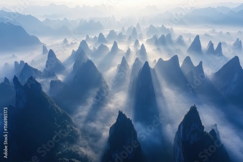 The majestic mountains of China. The sun shines through the fog on top of many layers of mountain peaks, forming light spots like diamonds in the sky. Aerial photography perspective, high angle overhe photo