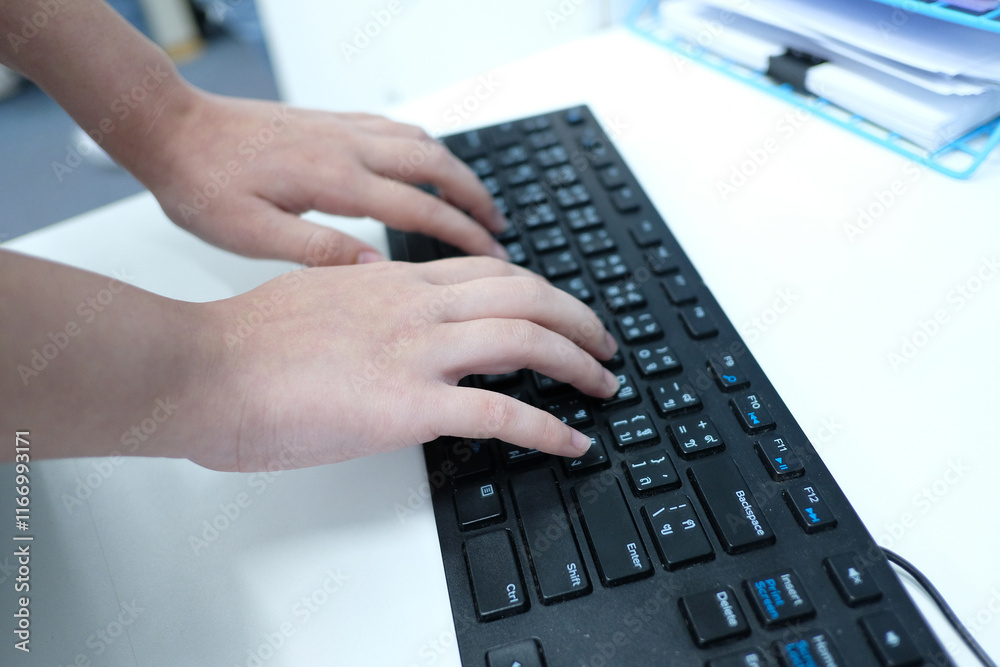 An employee is typing on a computer keyboard. An employee is typing on a computer keyboard.