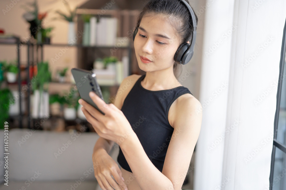 Fitness asian woman using smart phone and headphones Enjoy listening to music. Female with headphones smart phone after workout Fitness asian woman using smart phone and headphones Enjoy listening to music. Female with headphones smart phone after workout