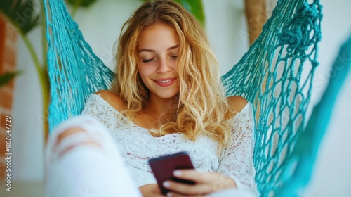 A relaxed woman lounges in a vibrant hammock, happily engaging with her smartphone, surrounded by a serene and inviting atmosphere photo