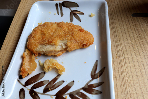 Photo of crispy chicken bites on a plate at a restaurant table