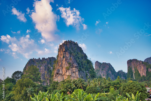 Towering limestone rocks and lush tropical vegetation in the soft glow of the evening sun. Ban Mung, Noen Maprang District, Phitsanulok Province, Thailand, holiday, vacation, nobody, light, sun
 photo