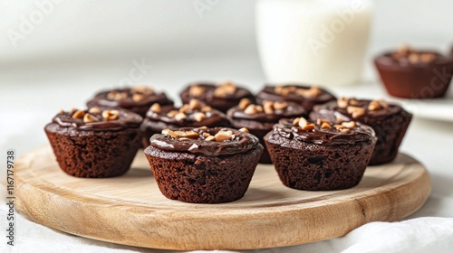 Delicious chocolate chip muffins arranged on a wooden board with milk in the ...
