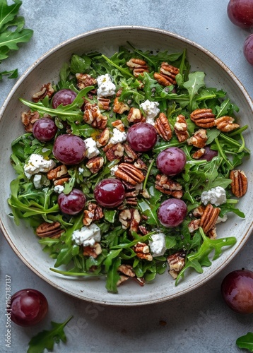 Delicious salad with arugula, grapes, pecans, and cheese served in a rustic bowl