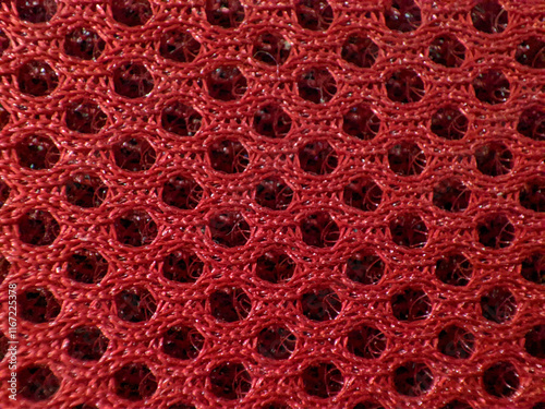 Close up Red breathable porous poriferous material for air ventilation with holes. Sportswear material nylon texture. photo