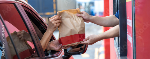 Hand Man in car receiving coffee in drive thru fast food restaurant. Staff serving takeaway order for driver in delivery window. Drive through and takeaway for buy fast food for protect covid19. photo