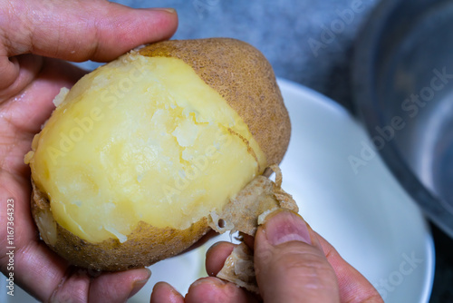 peeling the steamed potato with the hands
