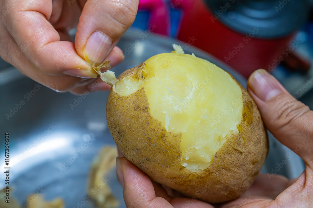 peeling the steamed potato with the hands