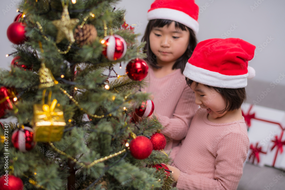 女の子たちが一緒に楽しむクリスマスツリーのデコレーション 女の子たちが一緒に楽しむクリスマスツリーのデコレーション
