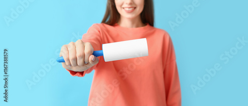 Young woman with lint rolle...