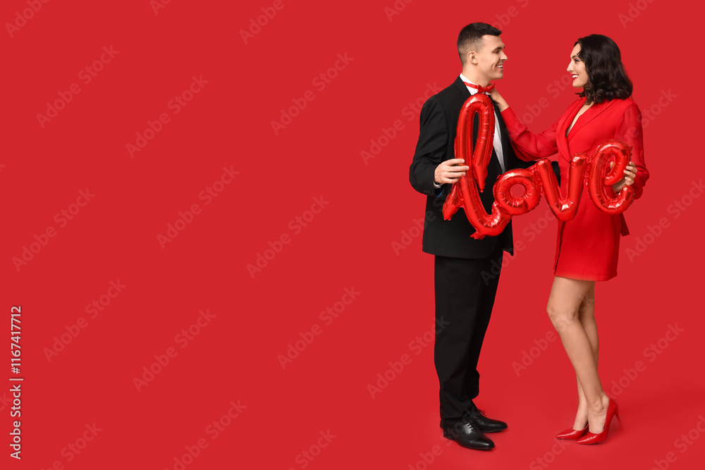 Loving young couple with balloon in shape of word LOVE on red background. Celebration of Saint Valentine's Day Loving young couple with balloon in shape of word LOVE on red background. Celebration of Saint Valentine's Day