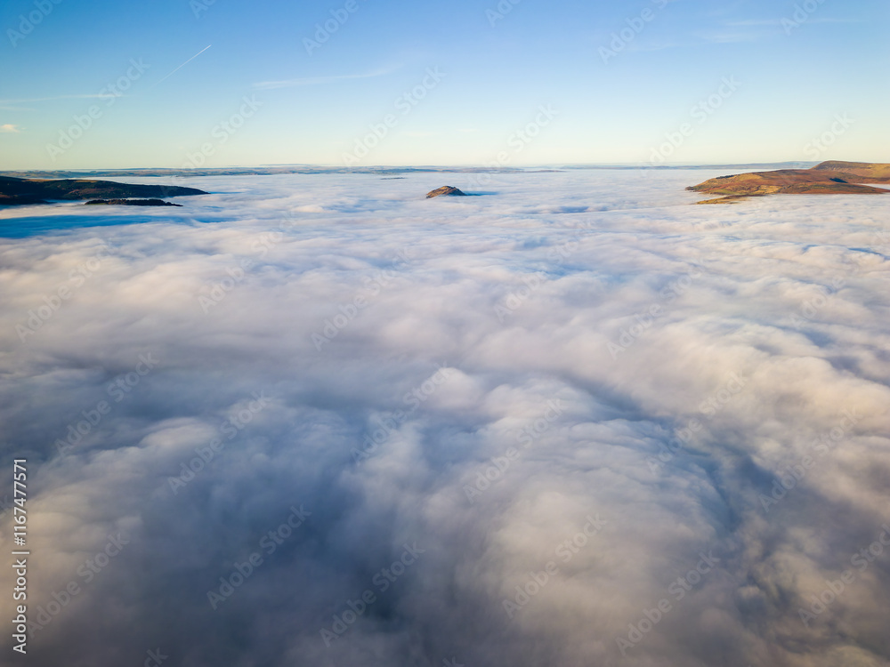 Obraz premium Aerial view of a sea of fog covering rural valleys and farmland