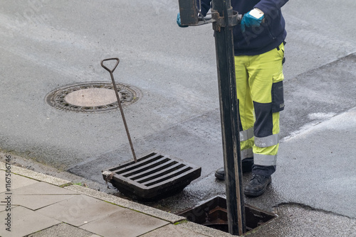 Fotografie Kanalreinigung Arbeiter in Sicherheitskleidung reinigt einen Gully mit Absaugvor
