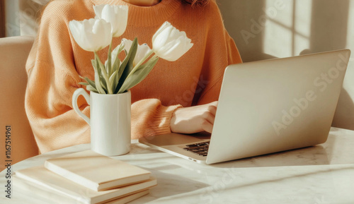 Woman freelance working on laptop with coffee and tulips, minimalist style, warm tones