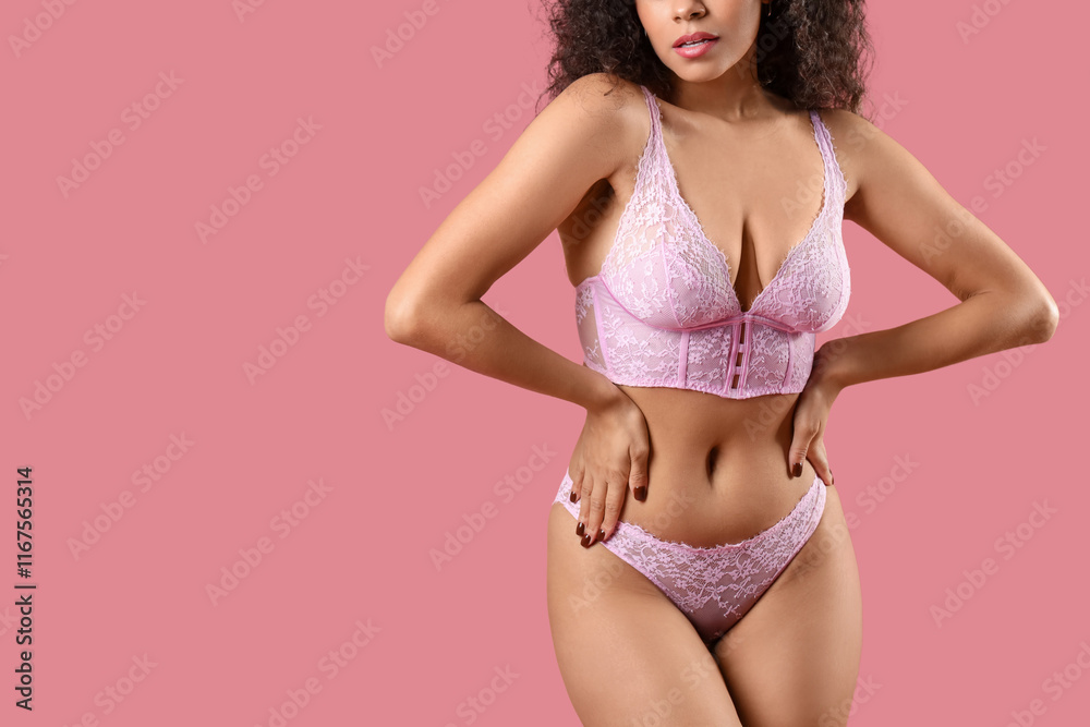 Naklejka premium Beautiful young African-American woman in elegant underwear on pink background, closeup