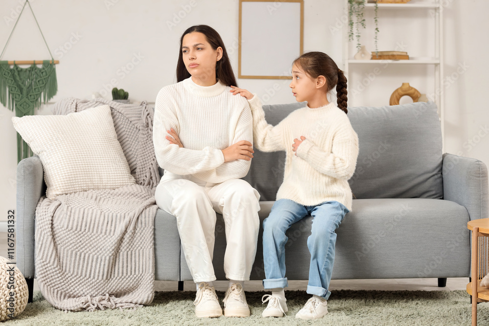Cute girl apologizing to her mother on sofa at home Cute girl apologizing to her mother on sofa at home