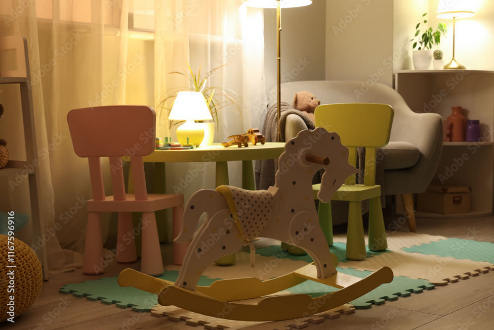 Obraz premium Interior of children's room with table, toys and glowing lamps at night